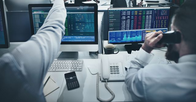 Una sala operativa con scrivanie e schermi di dati di mercato