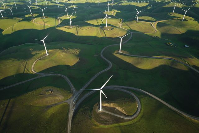 Turbine eoliche su colline verdi, viste dall’alto